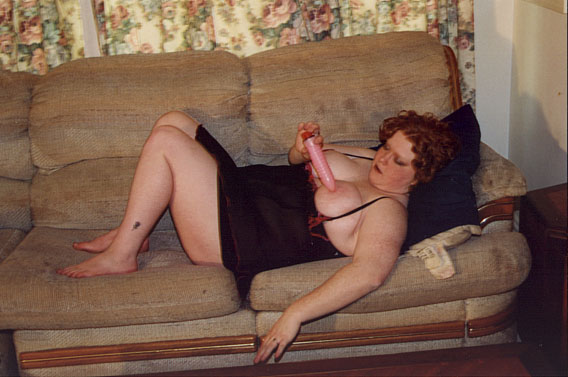 dicke rothaarige Frau spielt mit ihrem Vibrator an ihren Titten